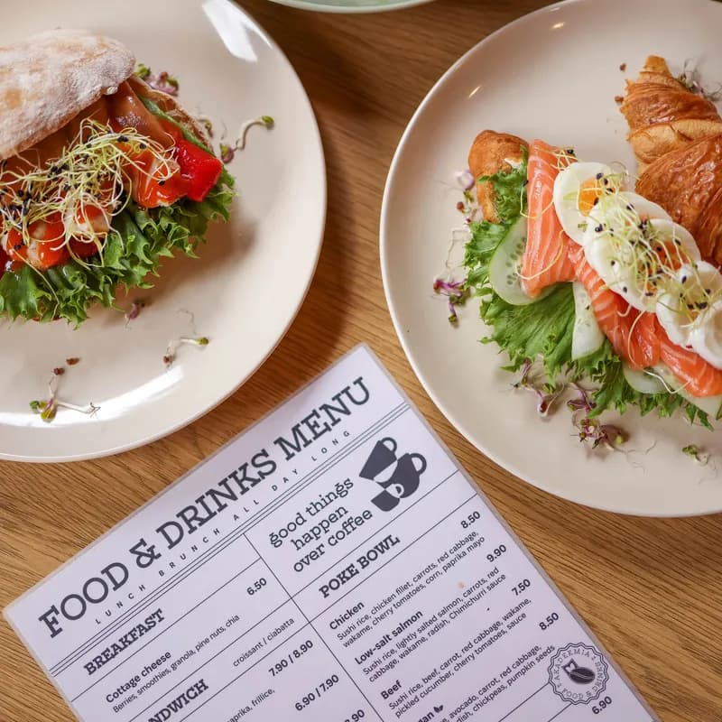 Top view of delicious salmon croissant and sandwich with fresh ingredients on wooden table.