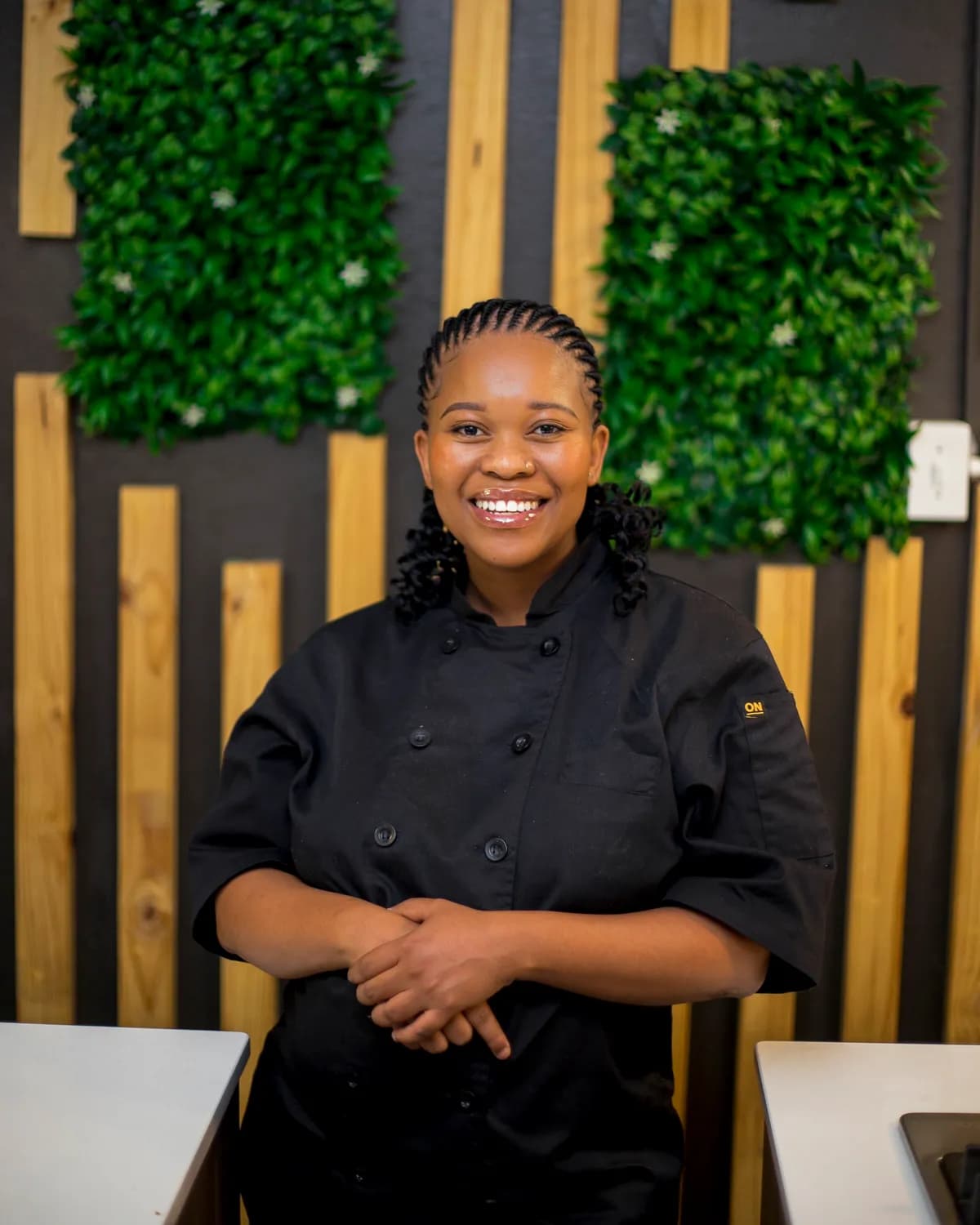 Chef Naledi smiling in the kitchen at Good Food Studio.
