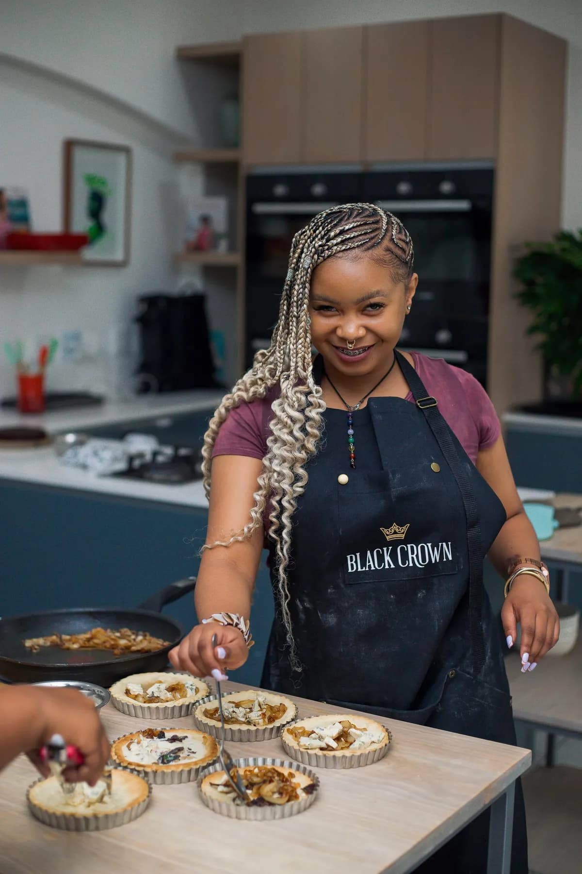 Guest smiling while filling tart shells during a hands-on cooking class.