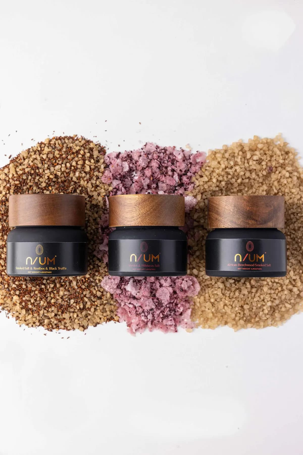 Three N/UM artisanal salt blends displayed over their different salt and seasoning textures.