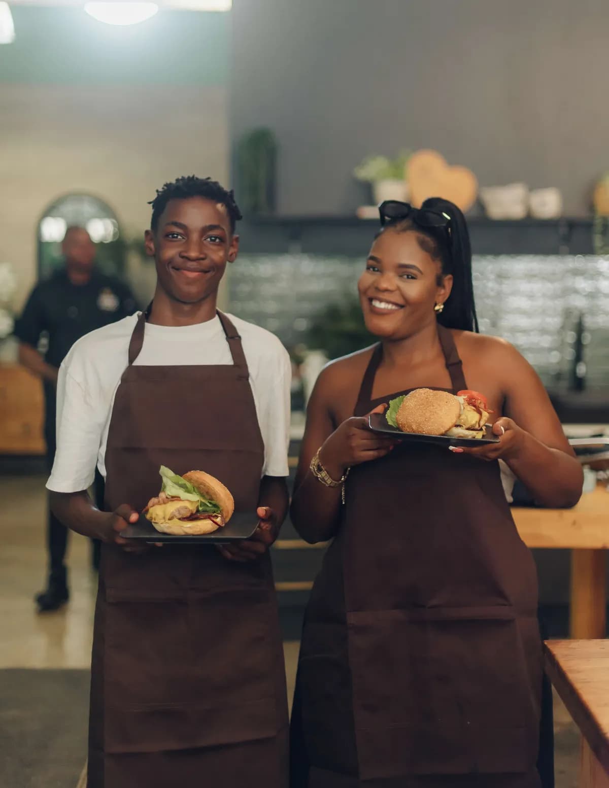 Mother and son holding homemade burgers during a Good Food Studio cooking class.